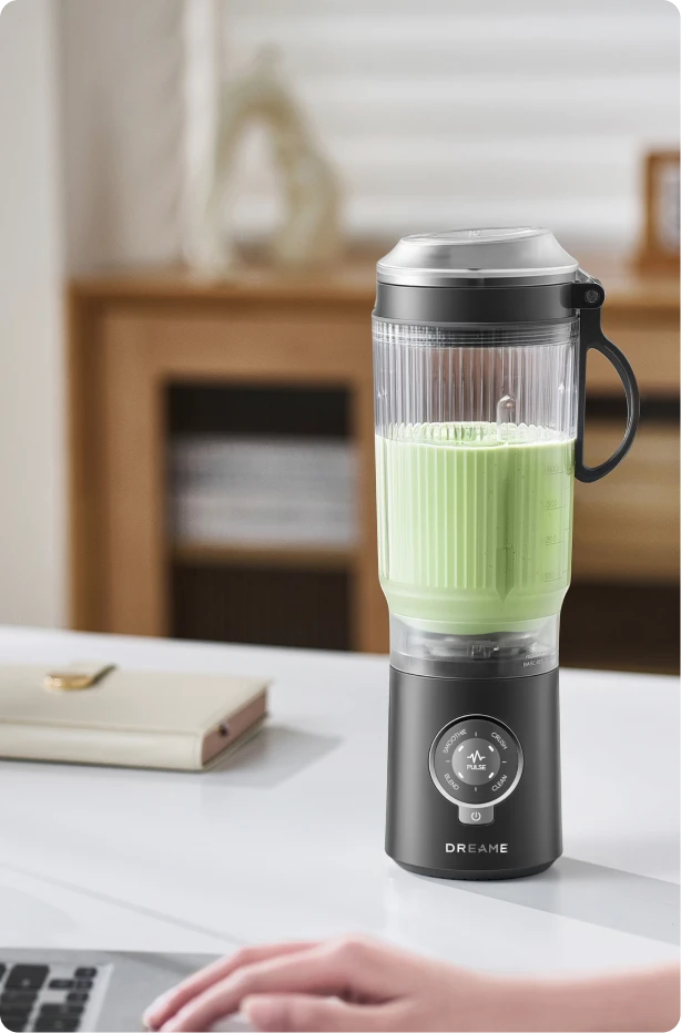 Dreame Portable Blender design sans fil sur un bureau préparant une boisson verte pendant le travail