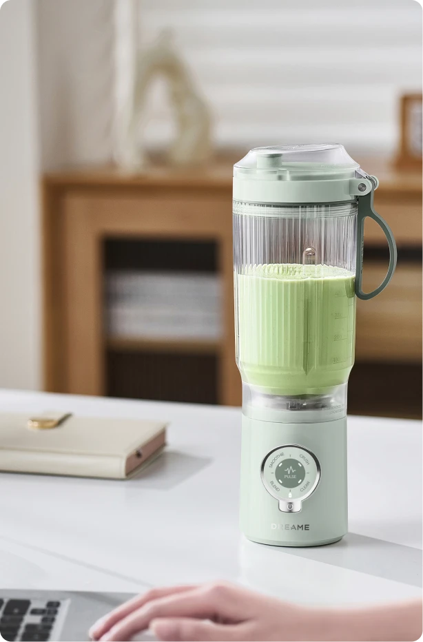 Dreame Portable Blender design sans fil sur un bureau préparant une boisson verte pendant le travail