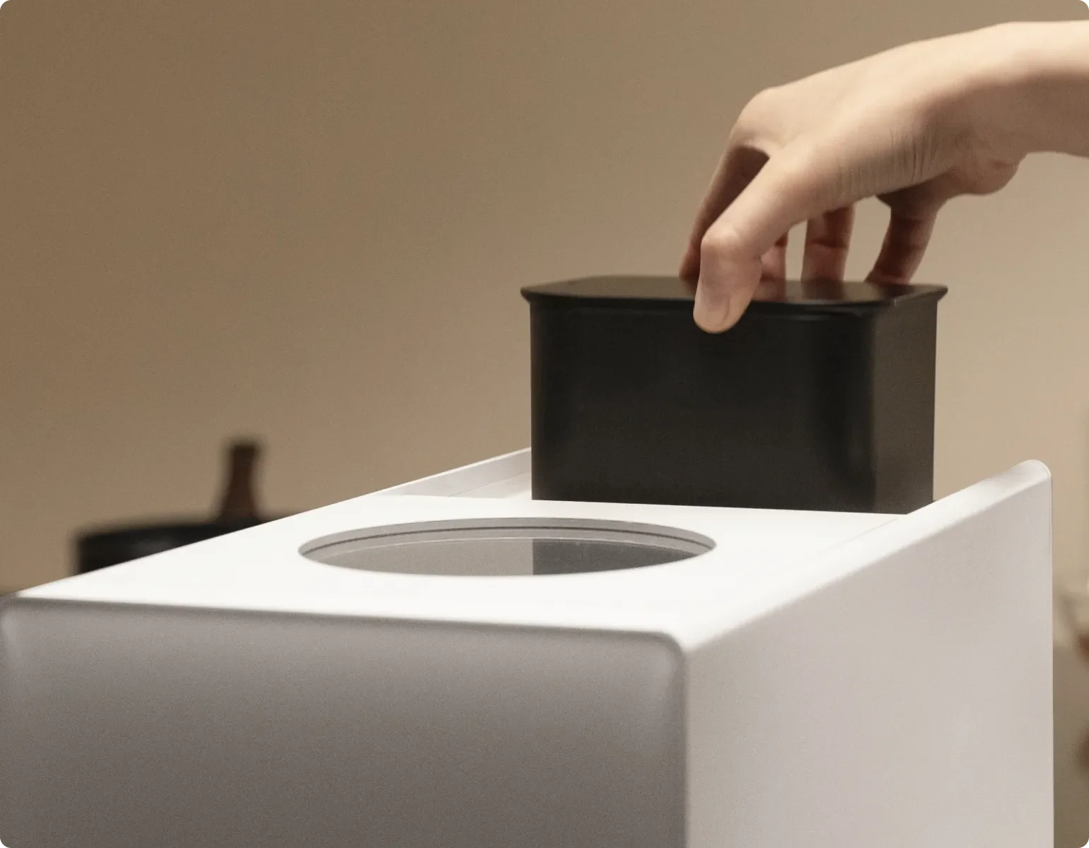 Une main insère le filtre à charbon actif dans le Dreame SF25 WiFi, qui neutralise les odeurs grâce à des matériaux purifiants de haute qualité à la source.